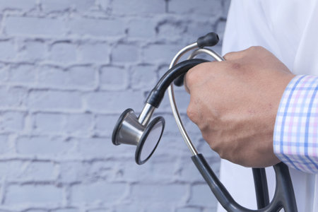 close up of doctor with arms crossed and stethoscope on hand