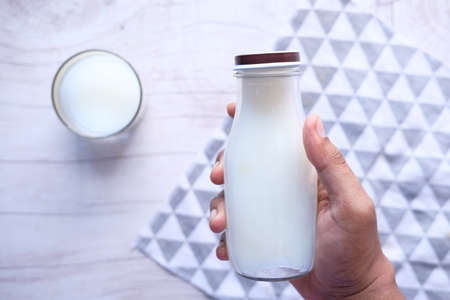 Top view man hand holding milk bottle.の写真素材