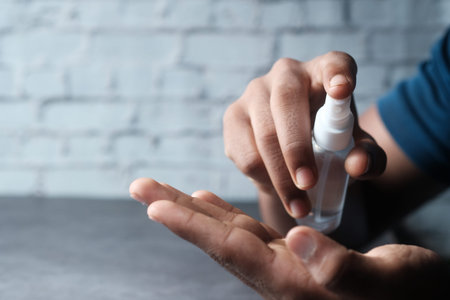 close up of young man hand using hand sanitizer spray.