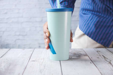 Hand holding stylish reusable eco coffee cup.の写真素材