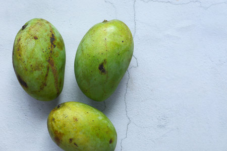 Fresh green mango on white background top down.