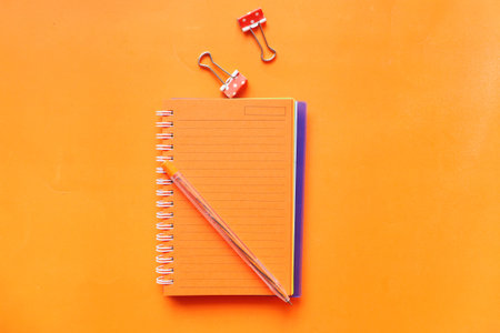 high angle view of open notepad on orange background