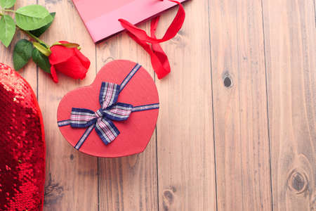 heart shape gift box , shopping bag and rose flower on tableの写真素材