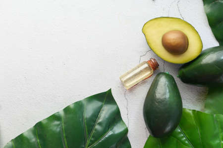 Top view of oil and slice of avocado on wooden tableの写真素材