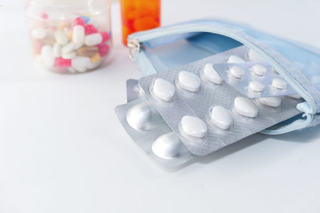 close up of colorful pills and blister pack on white background