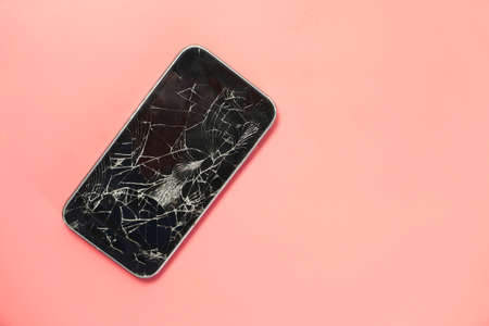 Top view of broken smart phone on color backgroundの写真素材