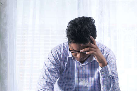 Depressed man feeling sick and worried about financial problemの写真素材