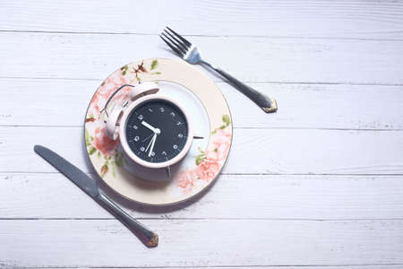 the concept of Healthy Food, alarm clock on plateの写真素材