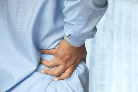young man suffering back pain close up
