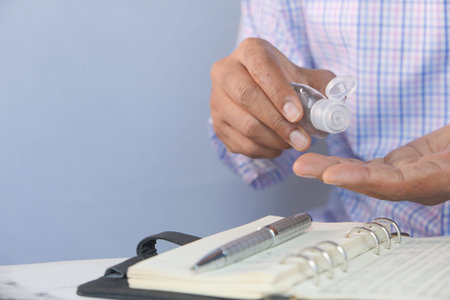 businessman using sanitizer gel on on office desk with copy space