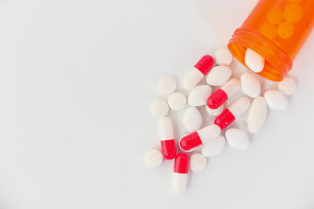 close up of colorful pills spilling on white background