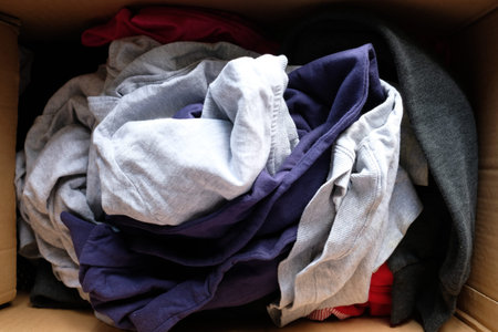 Donation box with donation clothes on a wooden table .