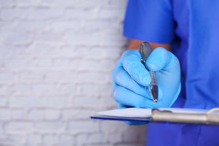 doctor hand in protective gloves writing prescription,の写真素材
