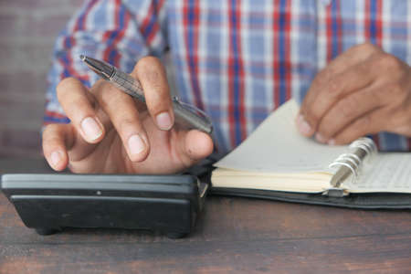 Close up of man hand using calculatorの写真素材