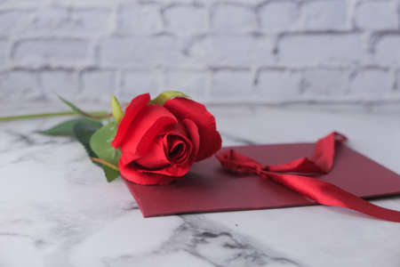 envelope and rose flower on white backgroundの写真素材