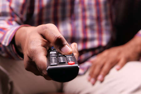 close up of man hand holding tv remote.の写真素材