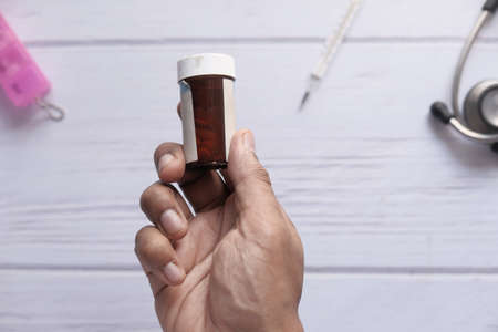 Close up of person hand holding pill containerの写真素材
