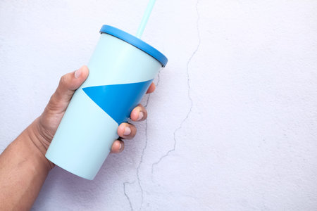 hand holding reusable eco coffee cup on table with copy space.