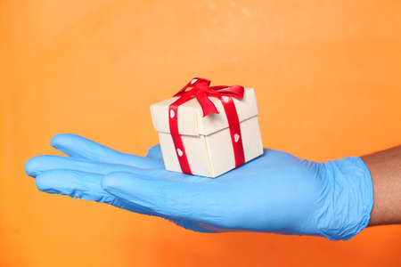 male hand in a blue medical glove gives a gift.の写真素材