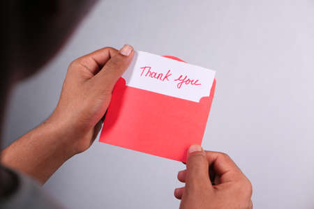 close up of man hand reading a thank you letterの写真素材