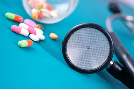 white pills and stethoscope on green background, close upの写真素材
