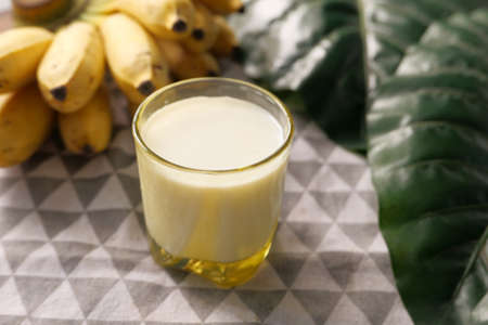 glass of milk and banana on table at morningの写真素材
