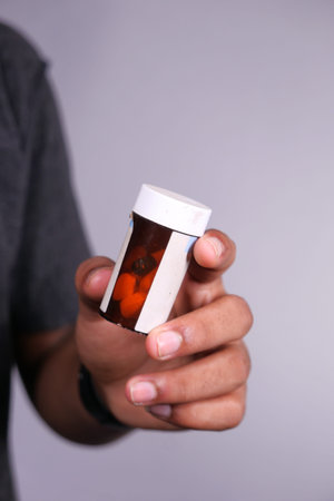 Close up of person hand holding pill container