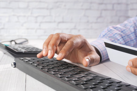man hands holding credit card and using keyboard shopping online
