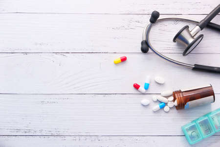 white pills and stethoscope on white backgroundの写真素材