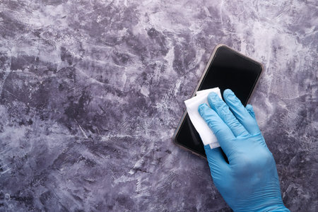 man hand cleaning mobile phone display.