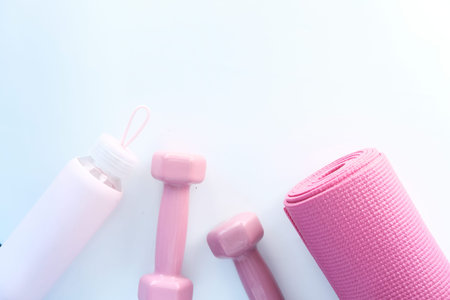 pink color dumbbell, exercise mat and water bottle on white backgroundの写真素材