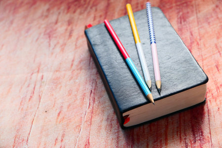 close up of a diary and pencils on table