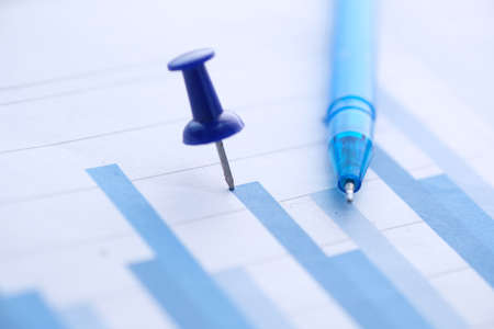 Close up of bar charts with push pin and pen on tableの写真素材