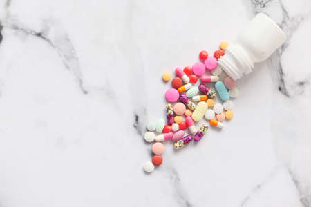 close up of colorful pills spilling on white backgroundの写真素材
