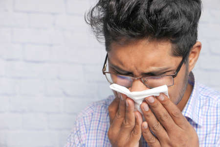 Portrait of sick man sneezes and coughsの写真素材