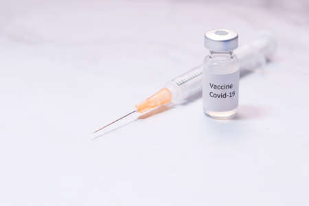 Close up of coronavirus vaccine and syringe on white backgroundの写真素材