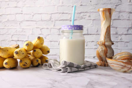 glass of milk and banana on table at morningの写真素材