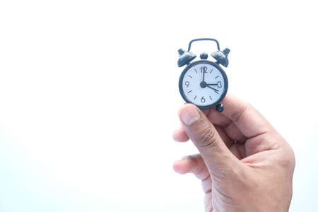 man hand holding alarm clock isolated on white,の写真素材