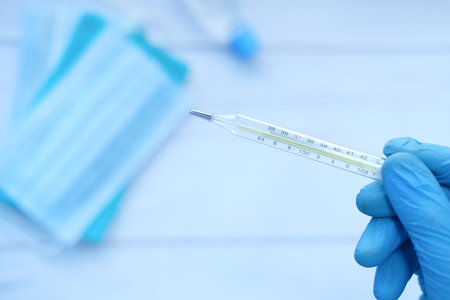 man hand holding medical thermometer on white background