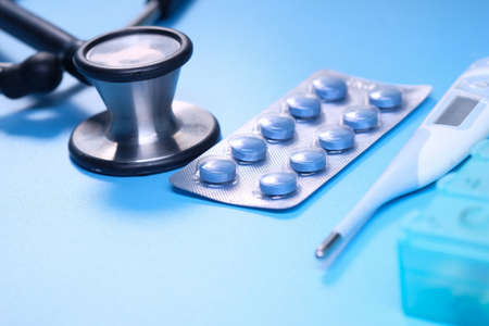 blister pack, thermometer and stethoscope on blue backgroundの写真素材