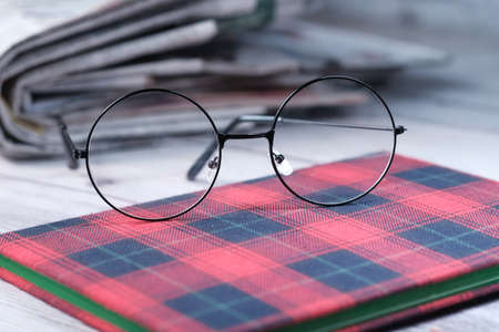 eyeglass, notepad and newspaper on table .の写真素材