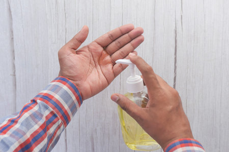 top view of young man hand using sanitizer gel for preventing virus