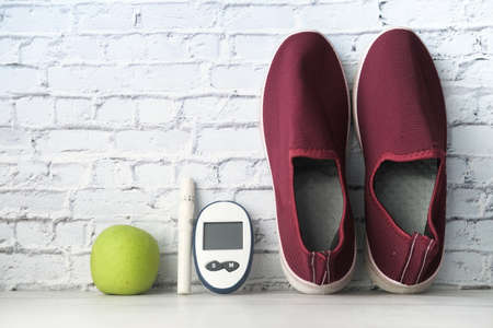 diabetic measurement tools, shoe and apple on tableの写真素材