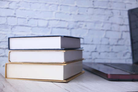 stack of books and laptop on tableの写真素材