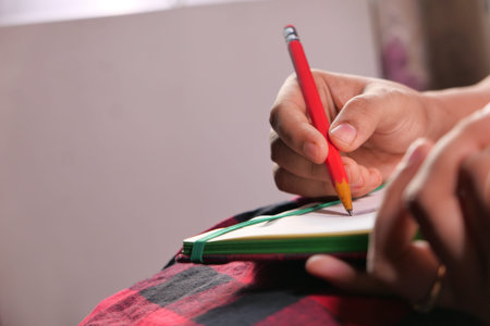 Close up of women hand writing on notepad.