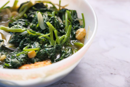 Close up of bowl with cooked spinach on table