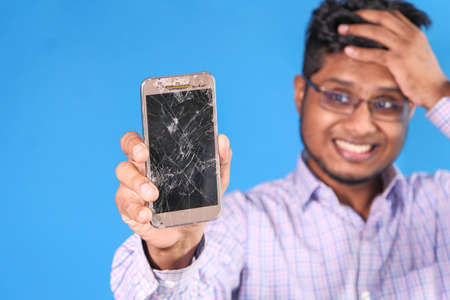 Close up of man hand holding broken smart phone.の写真素材