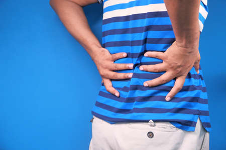 young man suffering back pain close upの写真素材
