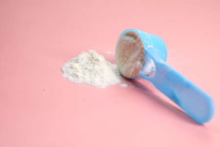 Close up of baby milk powder and spoon on pink background.の写真素材