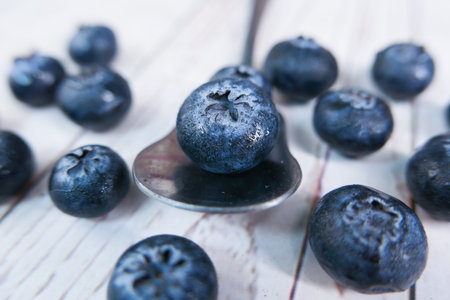 Close up of fresh blue berry fruits on spoon